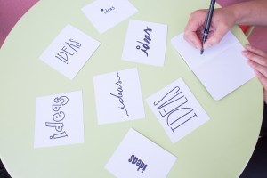 Stock photo of someone writing "IDEAS" on a bunch of different index cards