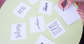 Stock photo of someone writing "IDEAS" on a bunch of different index cards