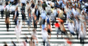 Blurry stock photo of a crowd of people in a crosswalk