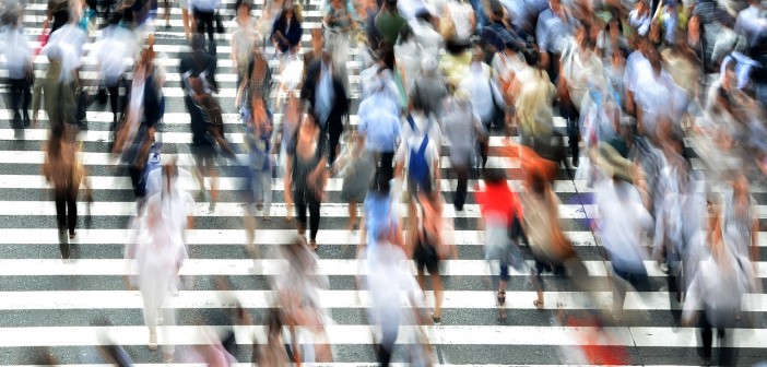 Blurry stock photo of a crowd of people in a crosswalk