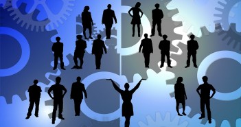 Clip art of a group of silhouettes of people in amidst a sea of gears