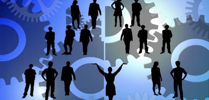 Clip art of a group of silhouettes of people in amidst a sea of gears