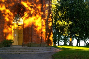 Stock photo of the exterior of a big brick church/chapel in a park.