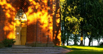 Stock photo of the exterior of a big brick church/chapel in a park.