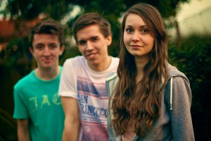 Stock photo of three white youth - two boys and one girl- outside