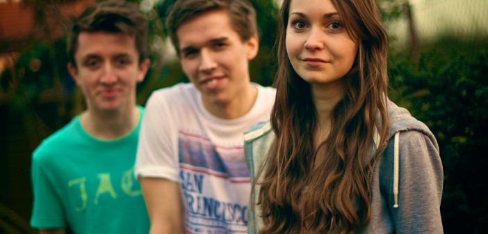 Stock photo of three white youth - two boys and one girl- outside