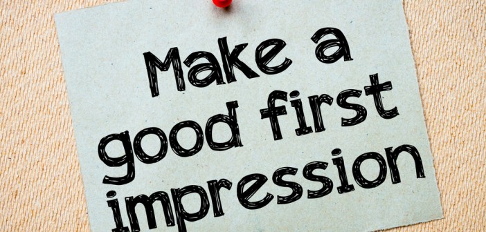 Stock photo of a notecard with "Make a good first impression" printed on it and tacked to a bulletin board