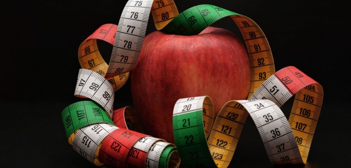 Photo of an apple draped with a measuring tape