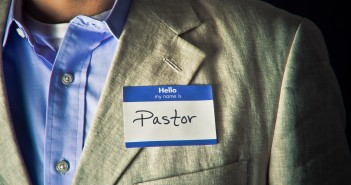 Stock photo of someone wearing a blazer and button down shirt with a nametag that reads "Hello my name is PASTOR"