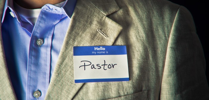 Stock photo of someone wearing a blazer and button down shirt with a nametag that reads "Hello my name is PASTOR"