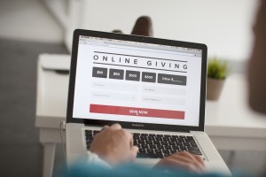 Stock photo of someone on their MacBook Pro on a website for online giving
