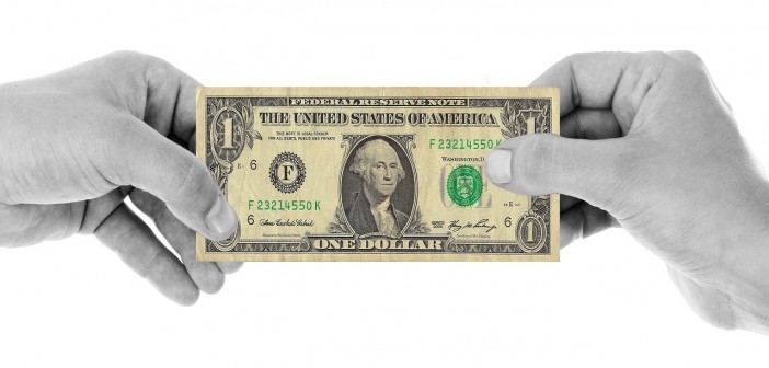 Stock photo of a black and white pair of hands holding a $1 bill