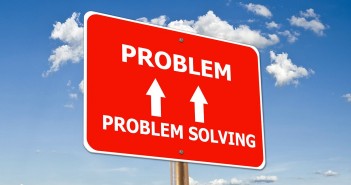 Stock photo of a road sign that has "PROBLEM SOLVING" with two arrows pointing up to "PROBLEM"