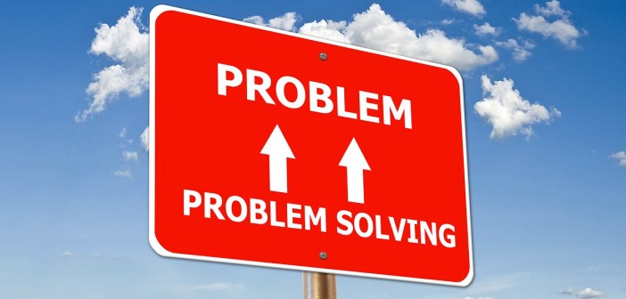 Stock photo of a road sign that has "PROBLEM SOLVING" with two arrows pointing up to "PROBLEM"