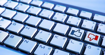 Stock photo of a keyboard that has a button for a thumbs-up and a button for a thumbs-down