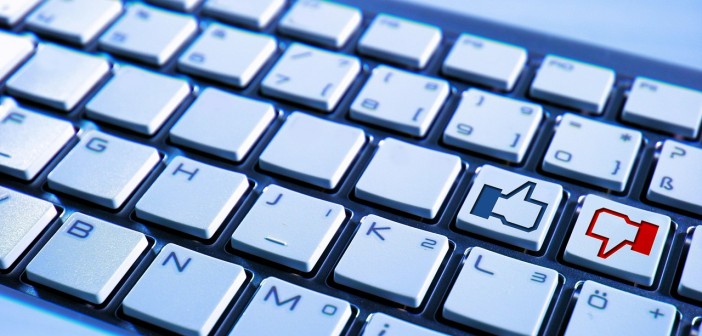 Stock photo of a keyboard that has a button for a thumbs-up and a button for a thumbs-down