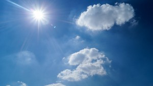 Stock photo of a clear, sunny sky with two fluffy clouds