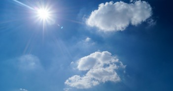 Stock photo of a clear, sunny sky with two fluffy clouds