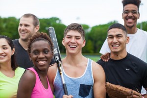 Stock photo of a mixed gender and mixed race group of young people after a pickup baseball or softball game