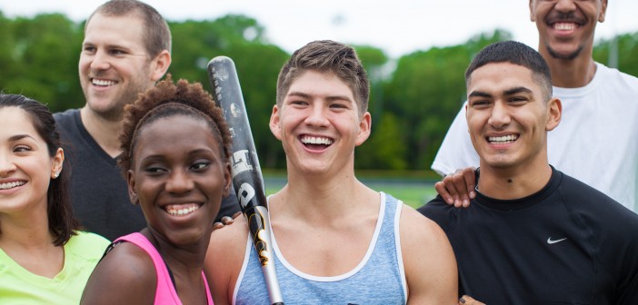 Stock photo of a mixed gender and mixed race group of young people after a pickup baseball or softball game