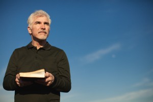 Stock photo of a middle-aged white man squinting outside on a beautiful day