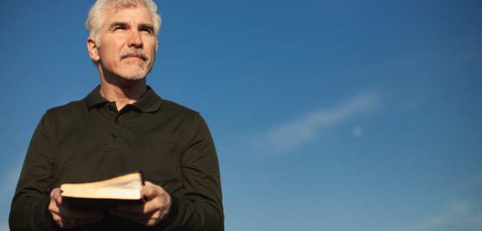 Stock photo of a middle-aged white man squinting outside on a beautiful day