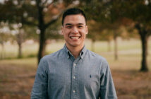 Smiling young pastor standing outside