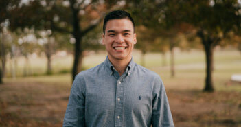 Smiling young pastor standing outside