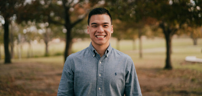 Smiling young pastor standing outside