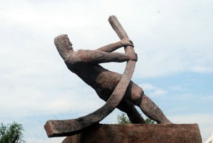 Stock photo of a statue of a man bending a metal pipe