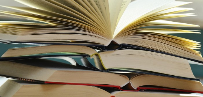 Stock photo of a stack of books that are opened and piled on top of each other