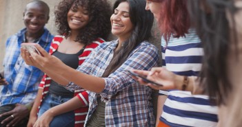 Stock photo of five young adults of mixed genders and races taking a selfie