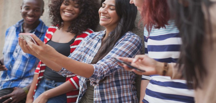 Stock photo of five young adults of mixed genders and races taking a selfie