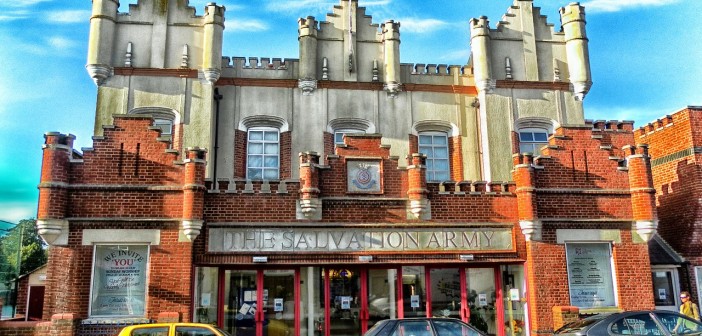 Stock photo of the exterior of a Salvation Army building with three cars parked outside of it