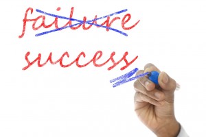 Stock photo of the word "failure" crossed out and the word "success" underlined beneath it