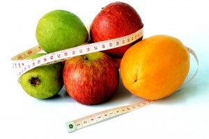 Stock photo of a pile of fruit with a measuring tape wrapped around them