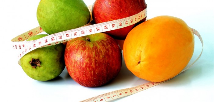 Stock photo of a pile of fruit with a measuring tape wrapped around them