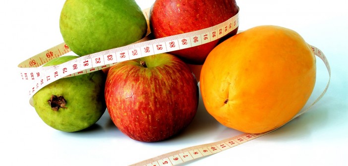 Stock photo of a pile of fruit with a measuring tape wrapped around them