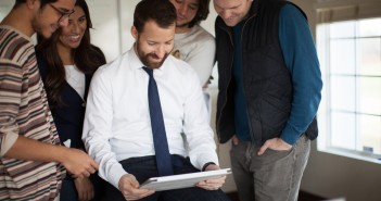 Stock photo of a group of mixed race and gender young professionals looking over a project