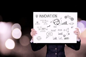 Stock photo of someone holding up a sign that says "INNOVATION" on it