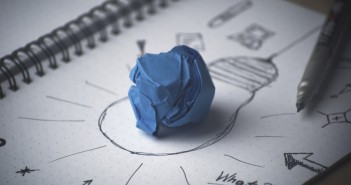 Stock photo of a crumpled up blue piece of paper on top of a drawing of a lightbulb