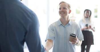 Church greeter shaking hands with a visitor