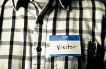 Person wearing a name tag that reads Hello my name is VISITOR