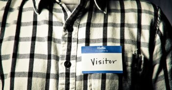 Person wearing a name tag that reads Hello my name is VISITOR