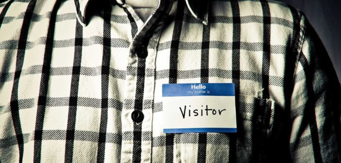 Person wearing a name tag that reads Hello my name is VISITOR