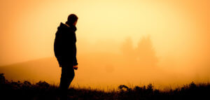 Hiker looking at a beautiful misty sunrise