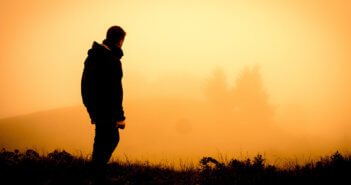 Hiker looking at a beautiful misty sunrise