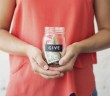 Photo of a young person holding a glass jar of money marked "Give"