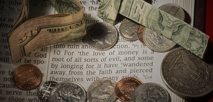 Cash and coins lying atop a Bible