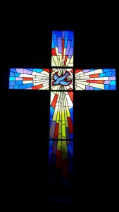 stock image of stained glass cross with dove
